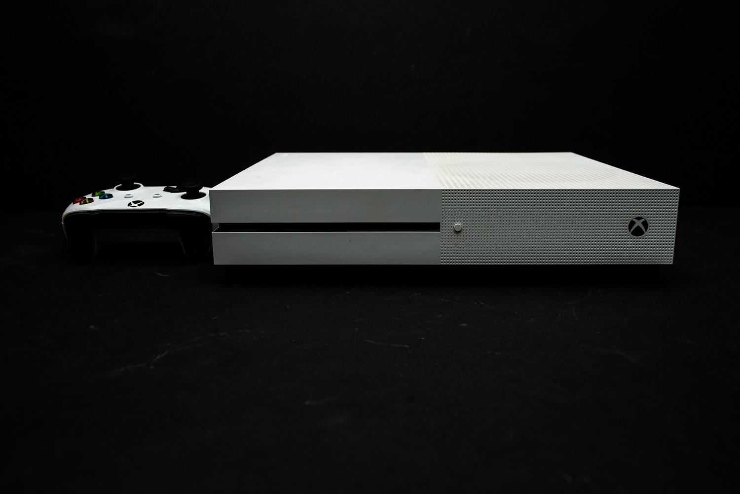 Consola Xbox blanca y mando sobre un fondo oscuro minimalista, aportando un aspecto premium y tecnológico.