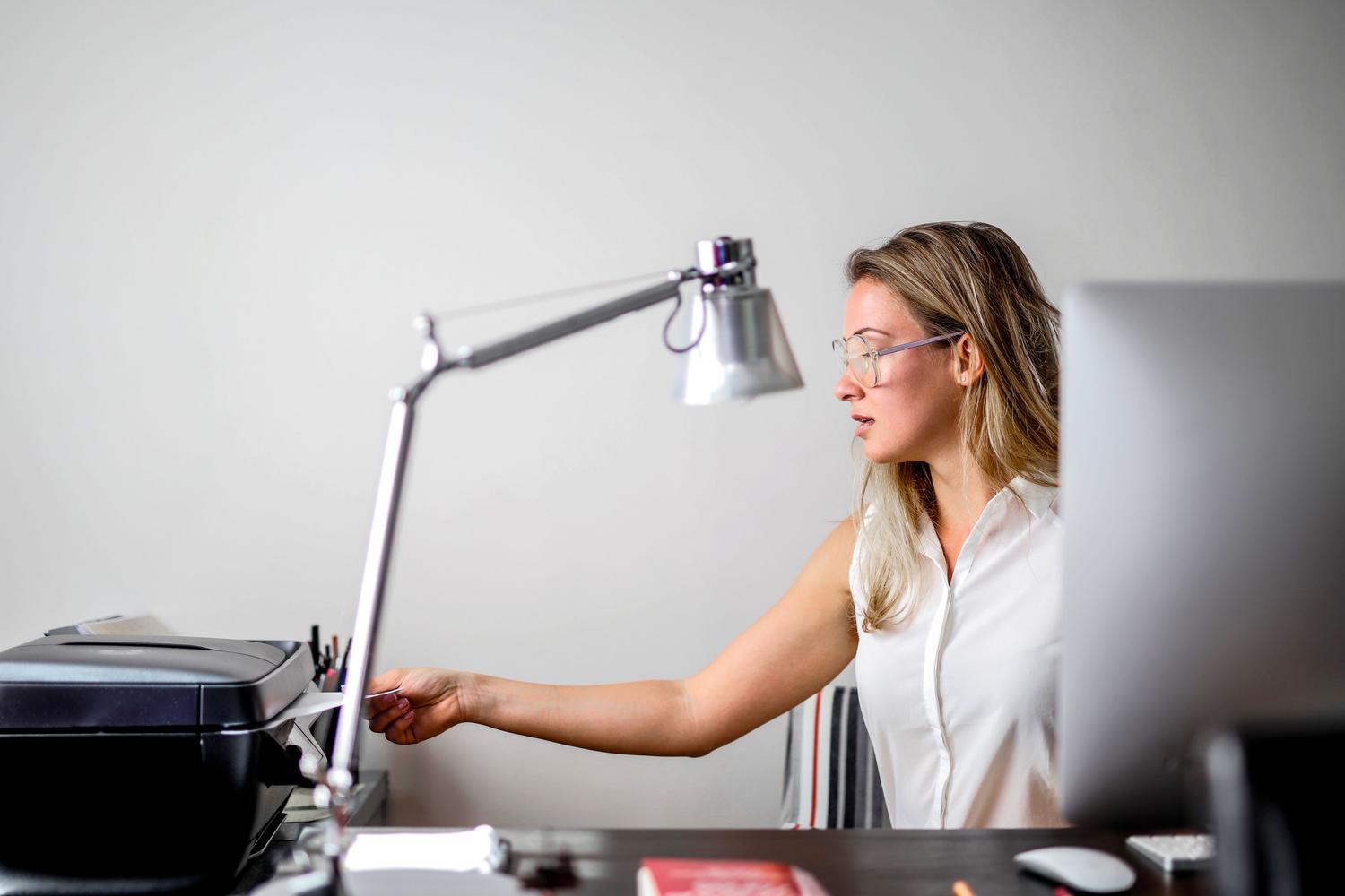 Mujer utilizando una impresora en una oficina.