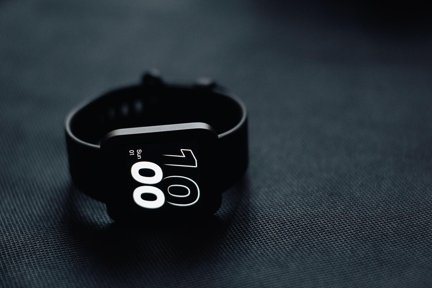 Reloj inteligente moderno sobre una superficie gris oscura, destacando la tecnología wearable.