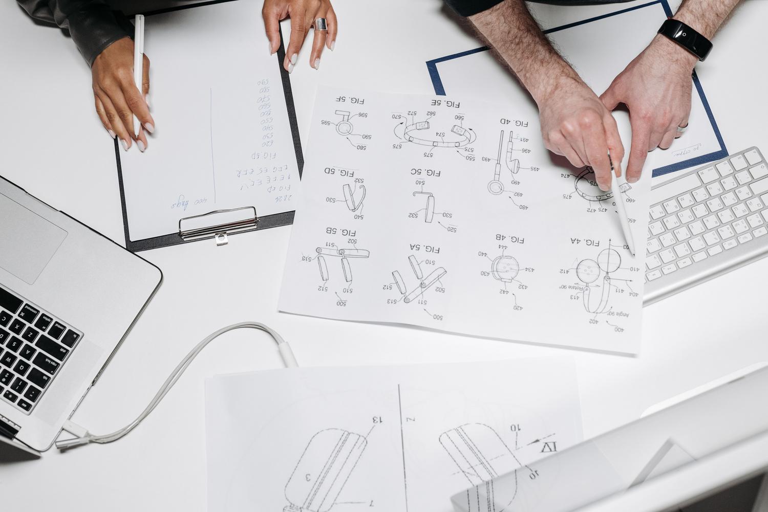 Profesionales colaborando con notas técnicas y planos, representando la documentación del saber hacer de una empresa para estandarizar la calidad