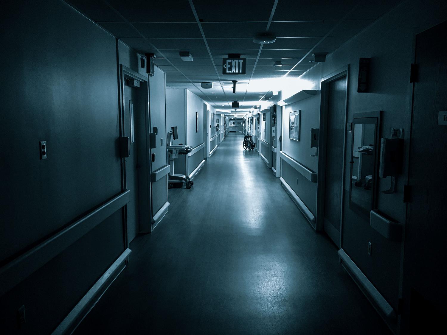 Pasillo vacío y mal iluminado de un hospital, evocando la atmósfera de los mapas de escape room y horror médico mencionados.