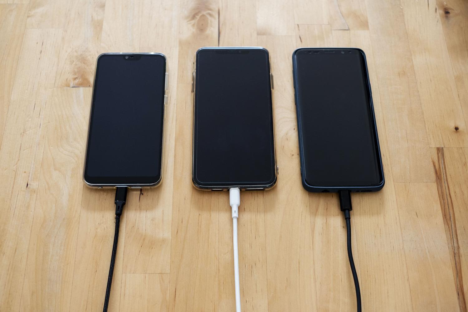 Smartphones Android cargando sobre una superficie de madera, ilustrando los reportes de temperatura elevada durante la carga nocturna.