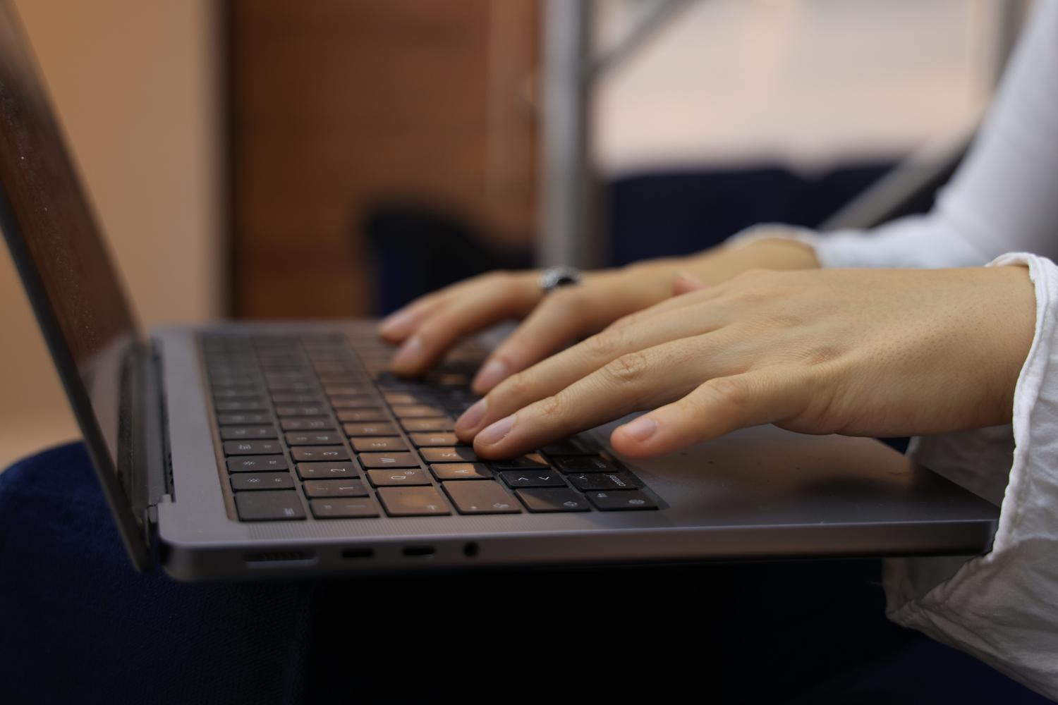 Primer plano de unas manos utilizando el teclado de un ordenador.