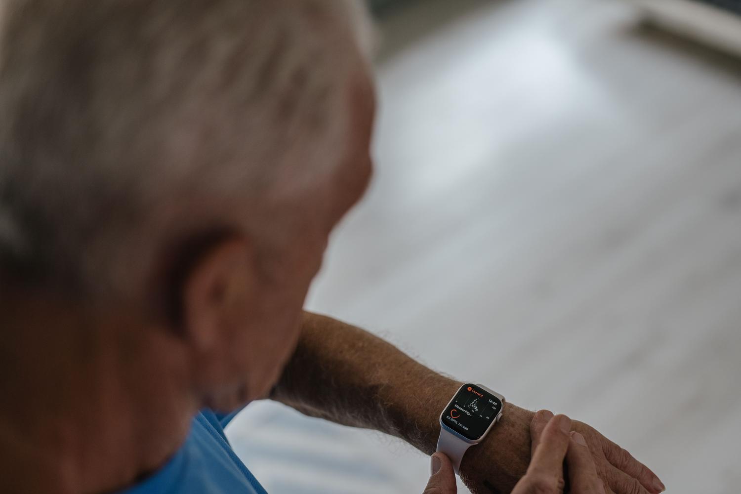 Hombre mayor utilizando la función de ECG de su reloj inteligente, demostrando que las herramientas de salud digital son accesibles para todas las edades.
