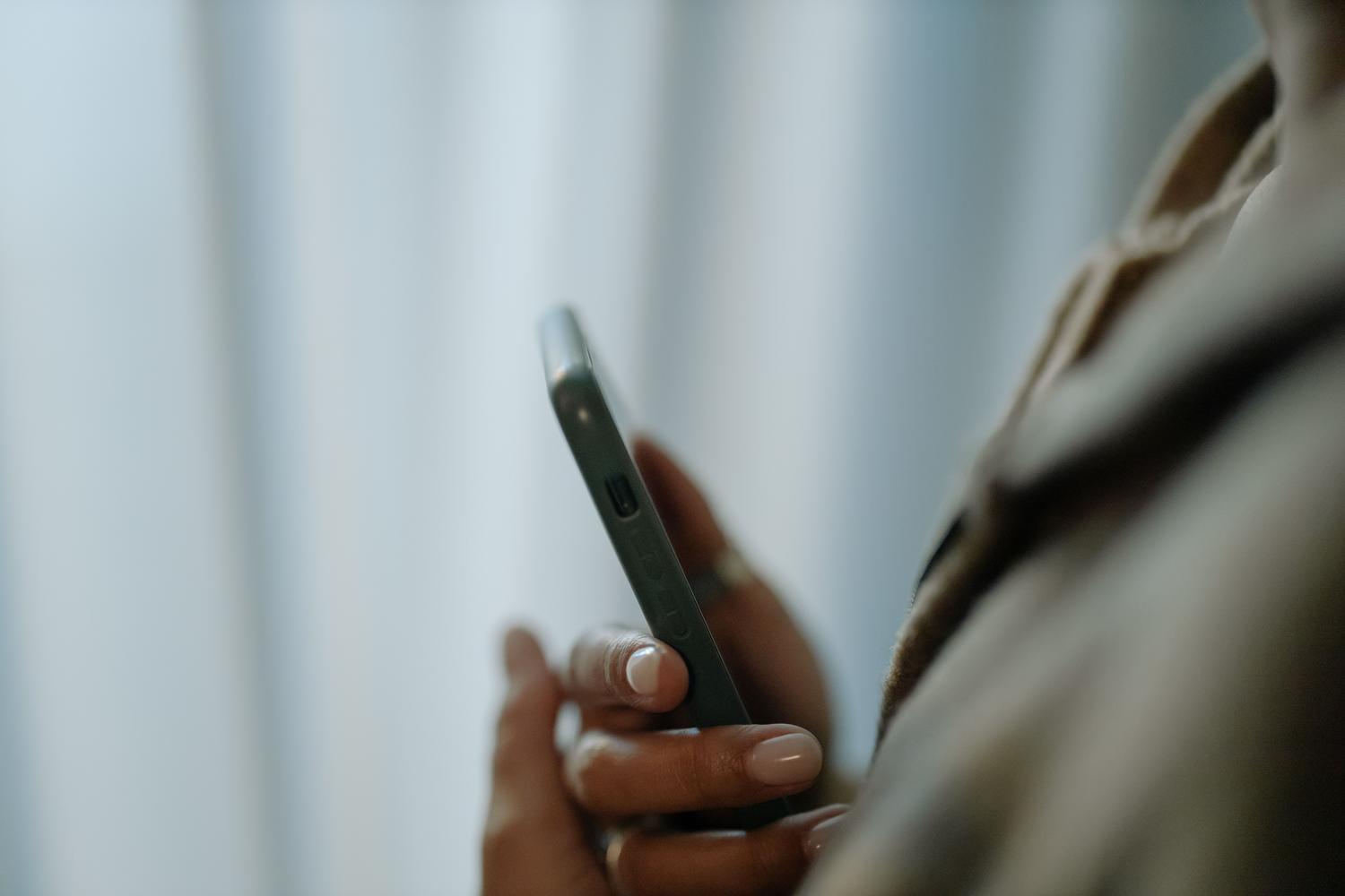 Detalle de una mano interactuando con la pantalla de un smartphone, evocando la configuración de ajustes del sistema.