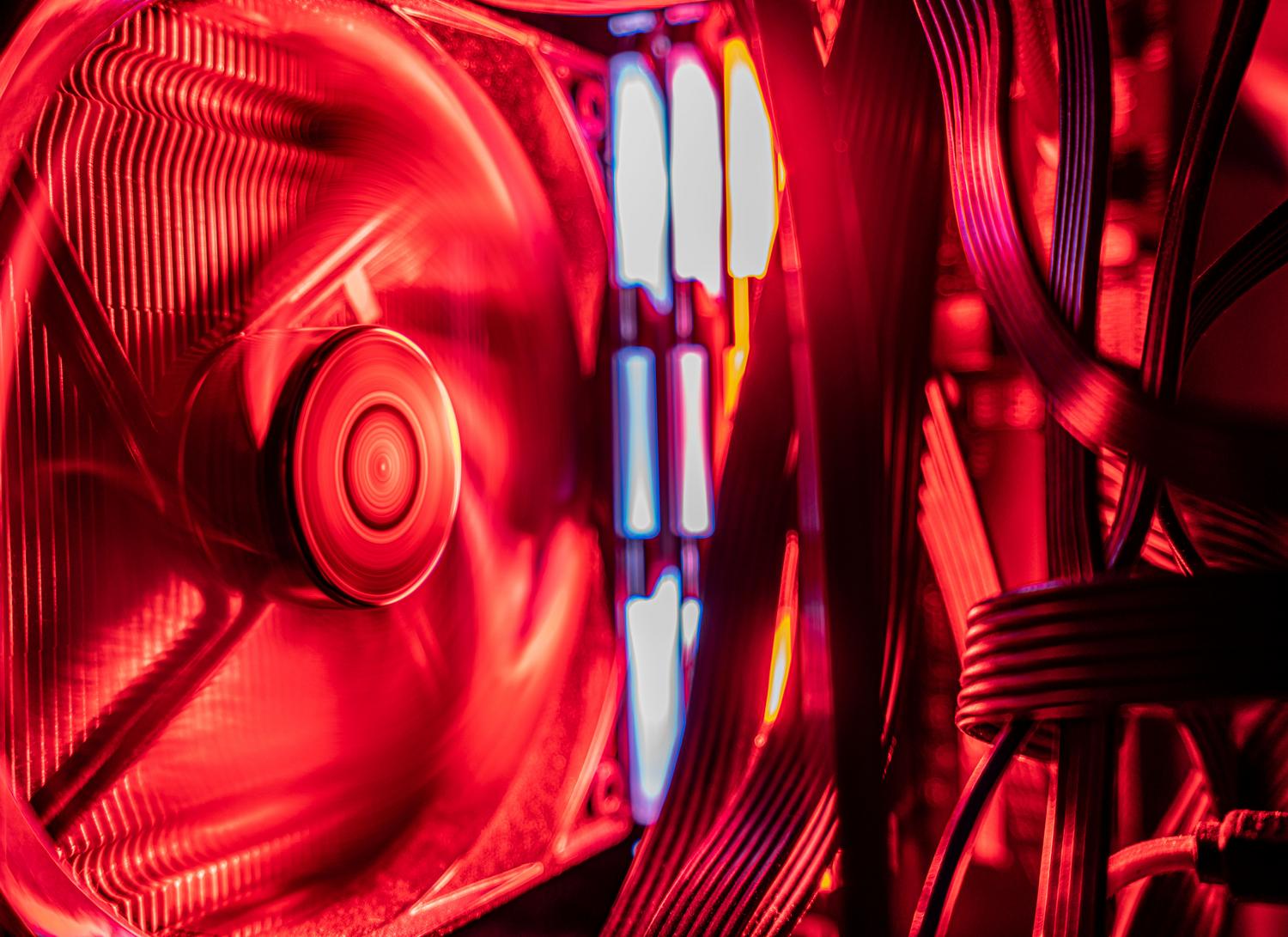 Componentes internos de un PC con iluminación roja y un ventilador en movimiento.