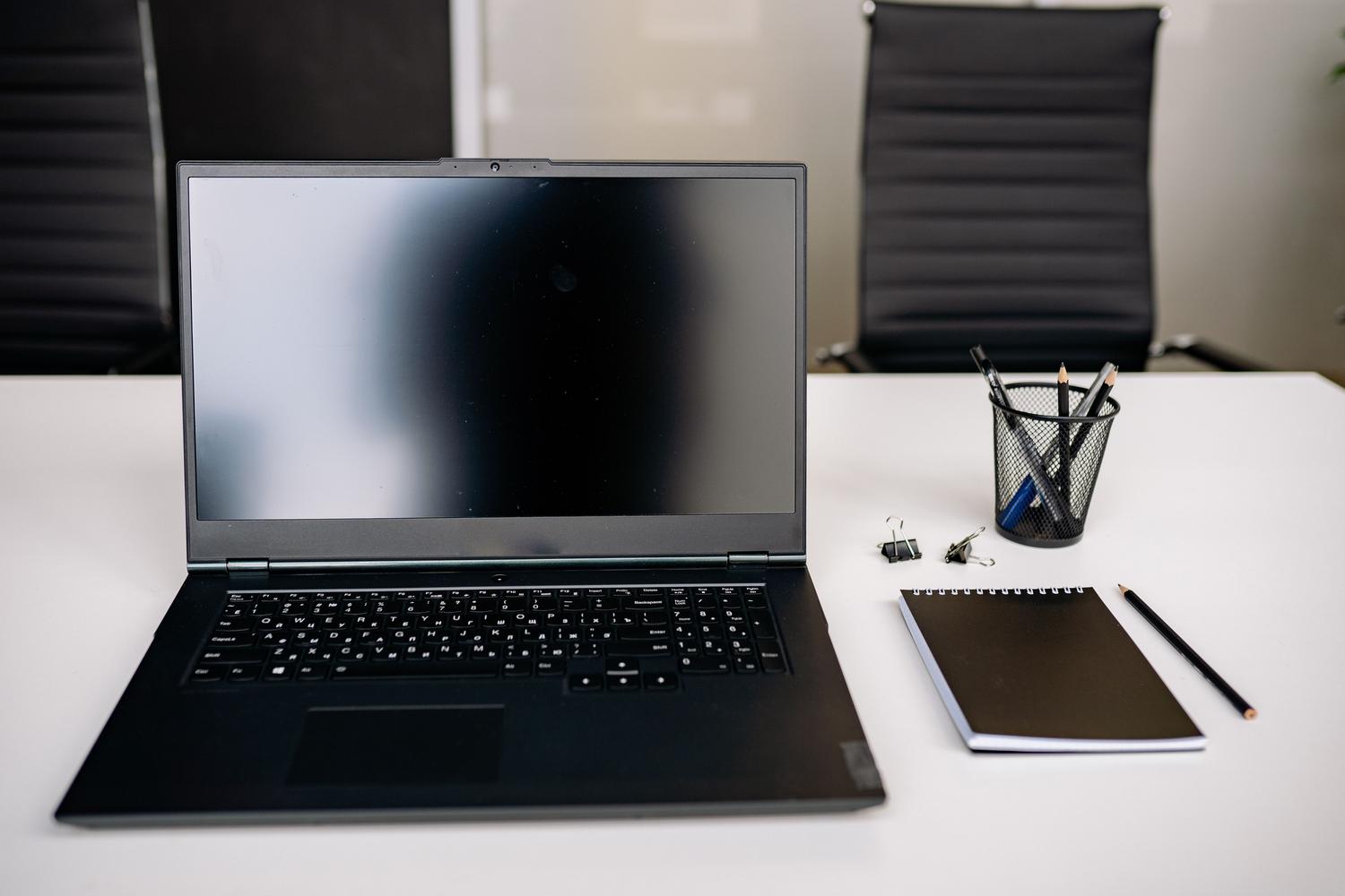 Espacio de trabajo limpio y organizado con un ordenador portátil y material de oficina sobre una mesa blanca, aportando una estética profesional y equilibrada al contenido.
