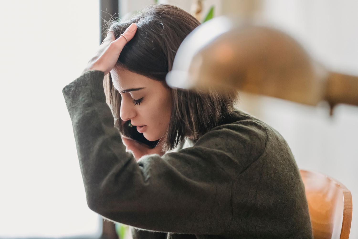Una mujer frustrada utilizando su teléfono móvil, ilustrando la dificultad de cancelar un pedido desde la aplicación.