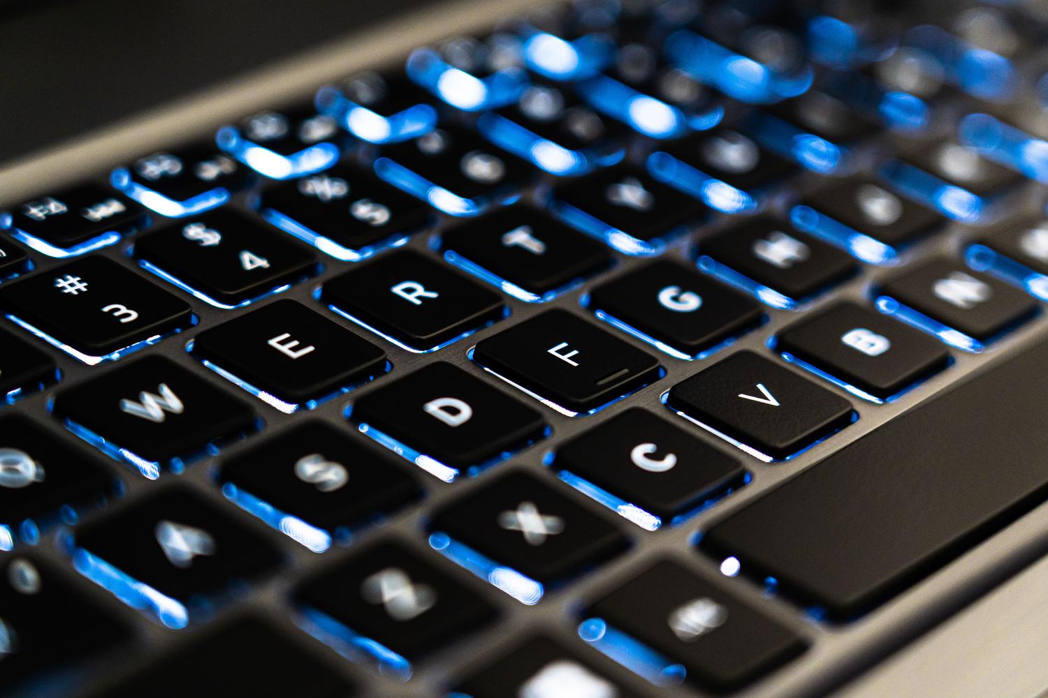 Teclado de portátil moderno con retroiluminación azul, imagen genérica de tecnología y computación.