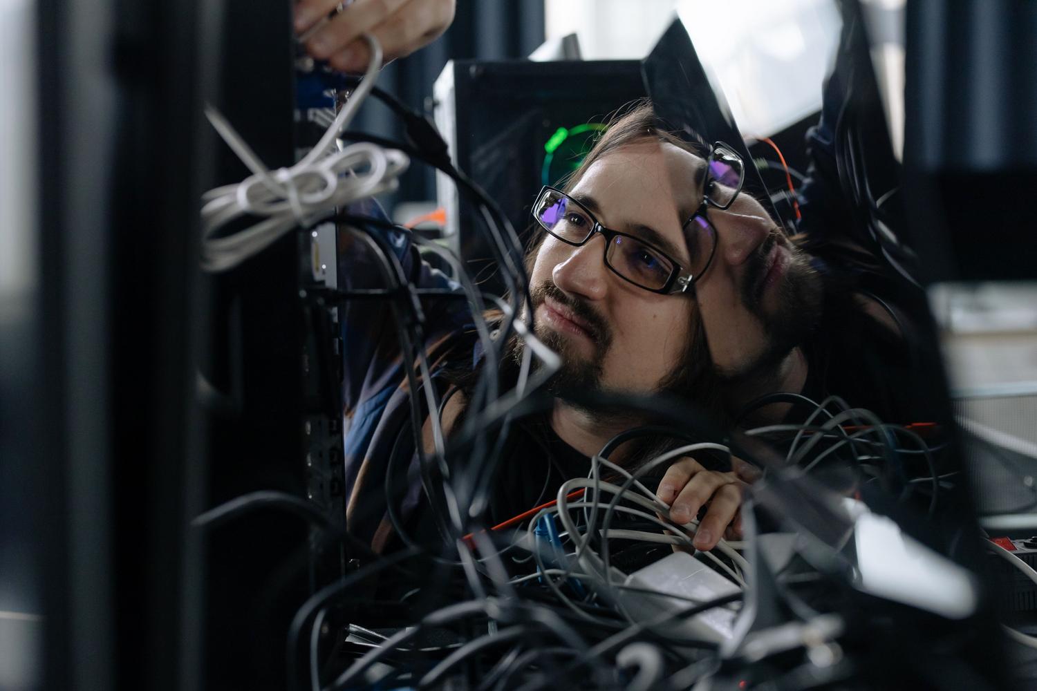 Técnico informático trabajando en el hardware de un ordenador, representando la solución de problemas técnicos.