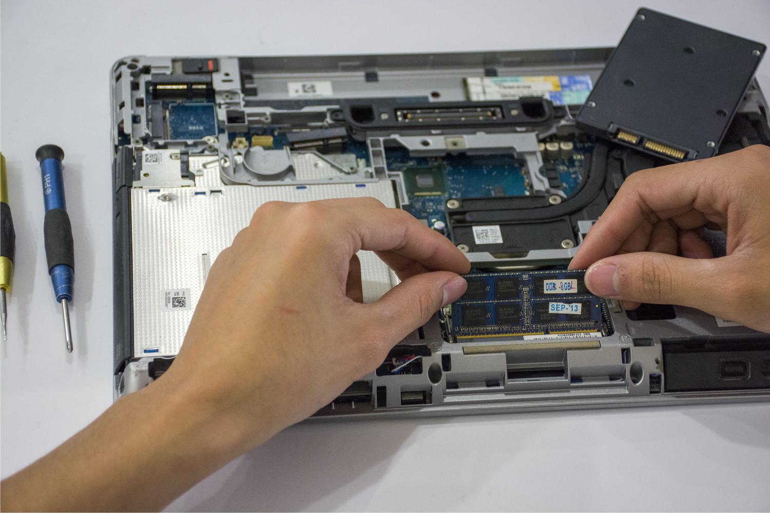Técnico instalando una unidad SSD NVMe en el interior de un ordenador.