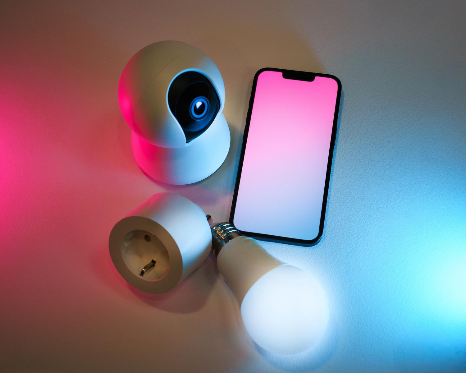 Fotografía profesional de dispositivos smart home con iluminación moderna y un smartphone para el control remoto.
