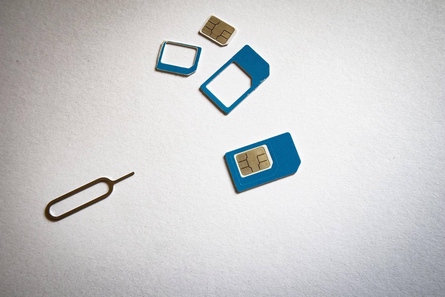 Tarjetas SIM y herramienta de extracción sobre fondo blanco, representando la tecnología de telecomunicaciones básica.