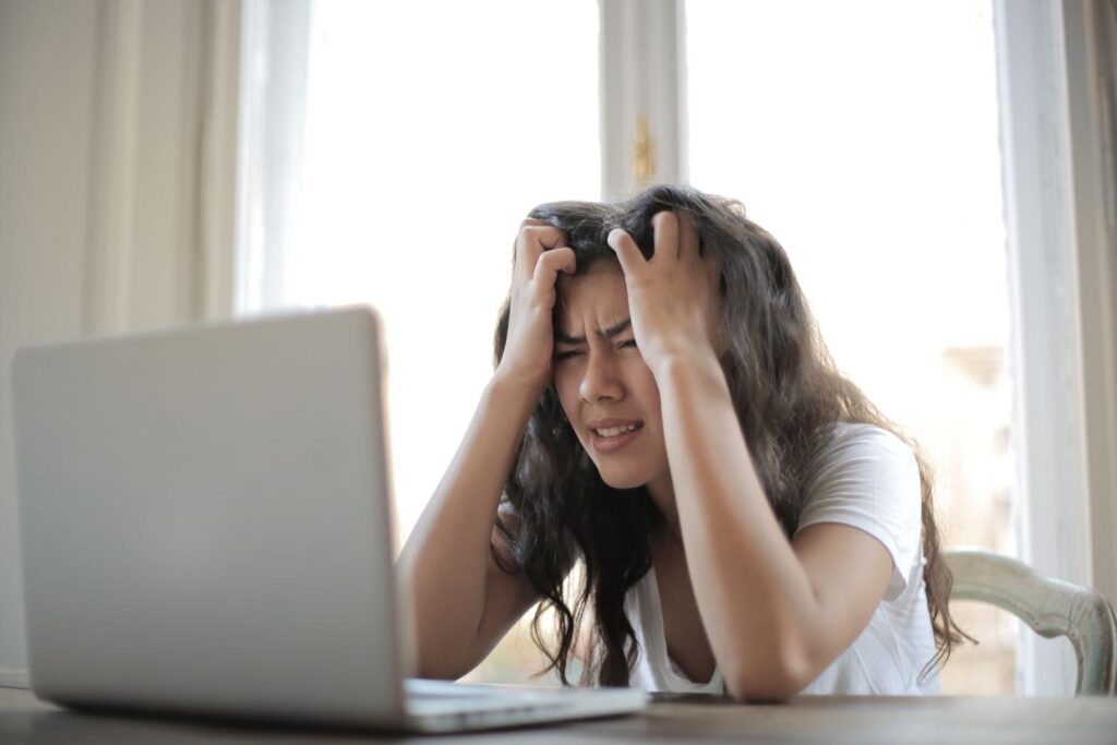 Mujer frustrada frente a su ordenador al encontrar un error de sistema como el Código 10.