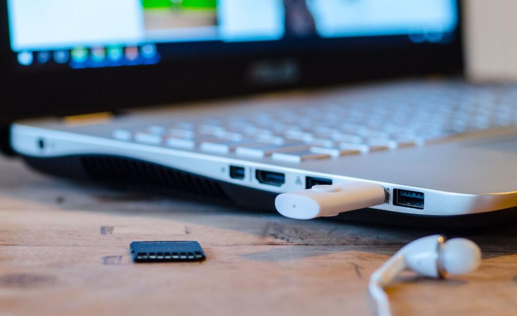 Laptop conectado a un dispositivo USB con auriculares al lado