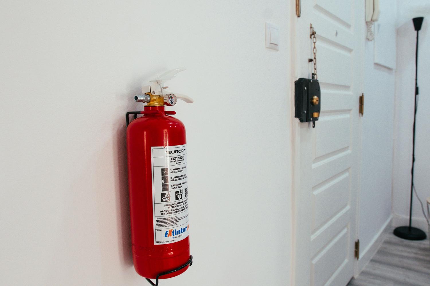 Extintor de incendios instalado en una pared blanca.