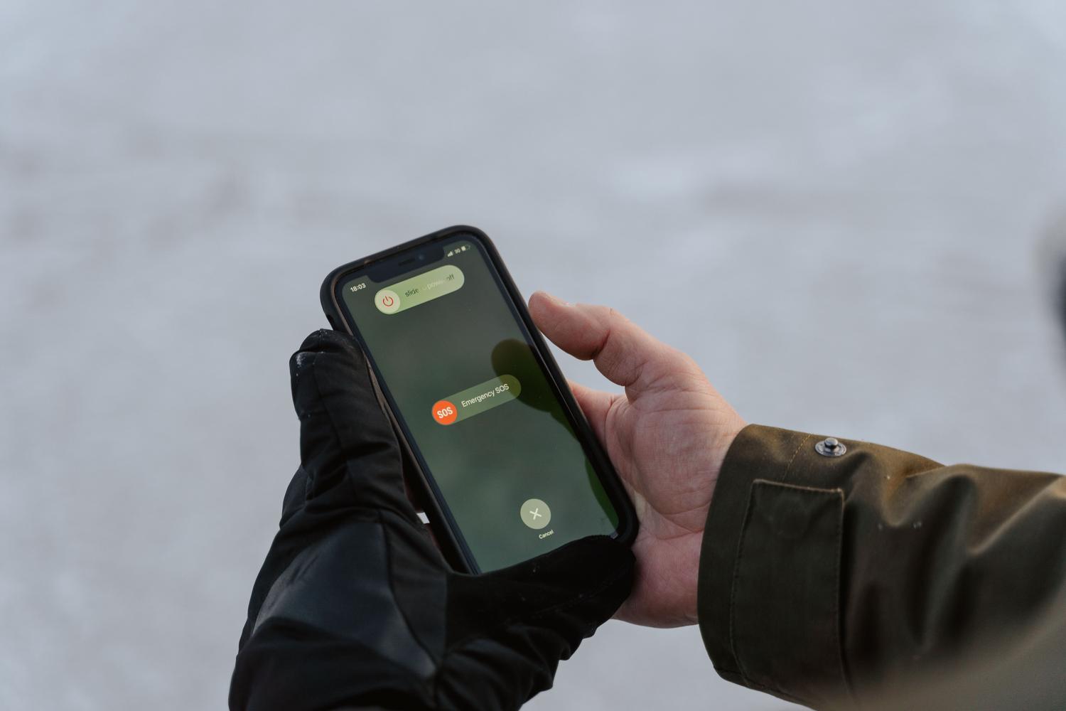 Persona sosteniendo un teléfono con una pantalla de emergencia SOS.