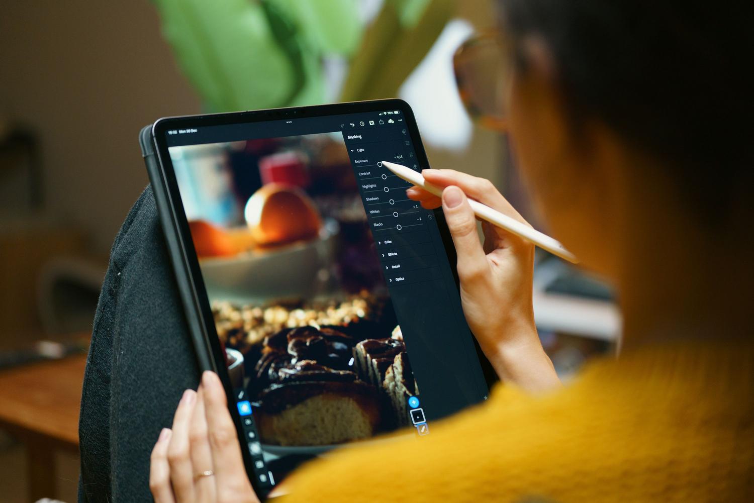 Persona utilizando una tableta y lápiz digital para editar una foto con precisión, representando el uso de herramientas avanzadas de edición.