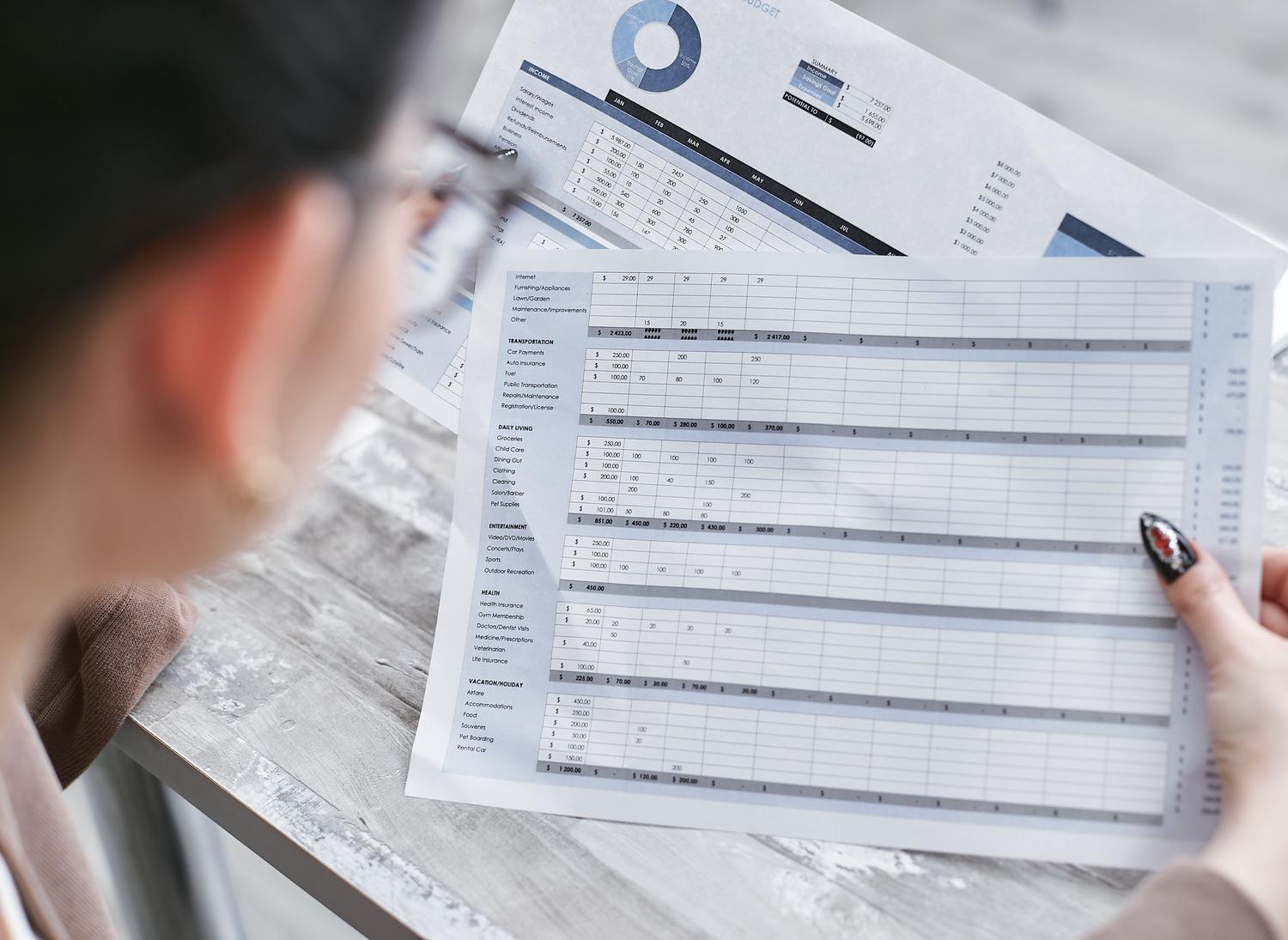 Profesional consultando documentos y hojas de cálculo en una oficina.
