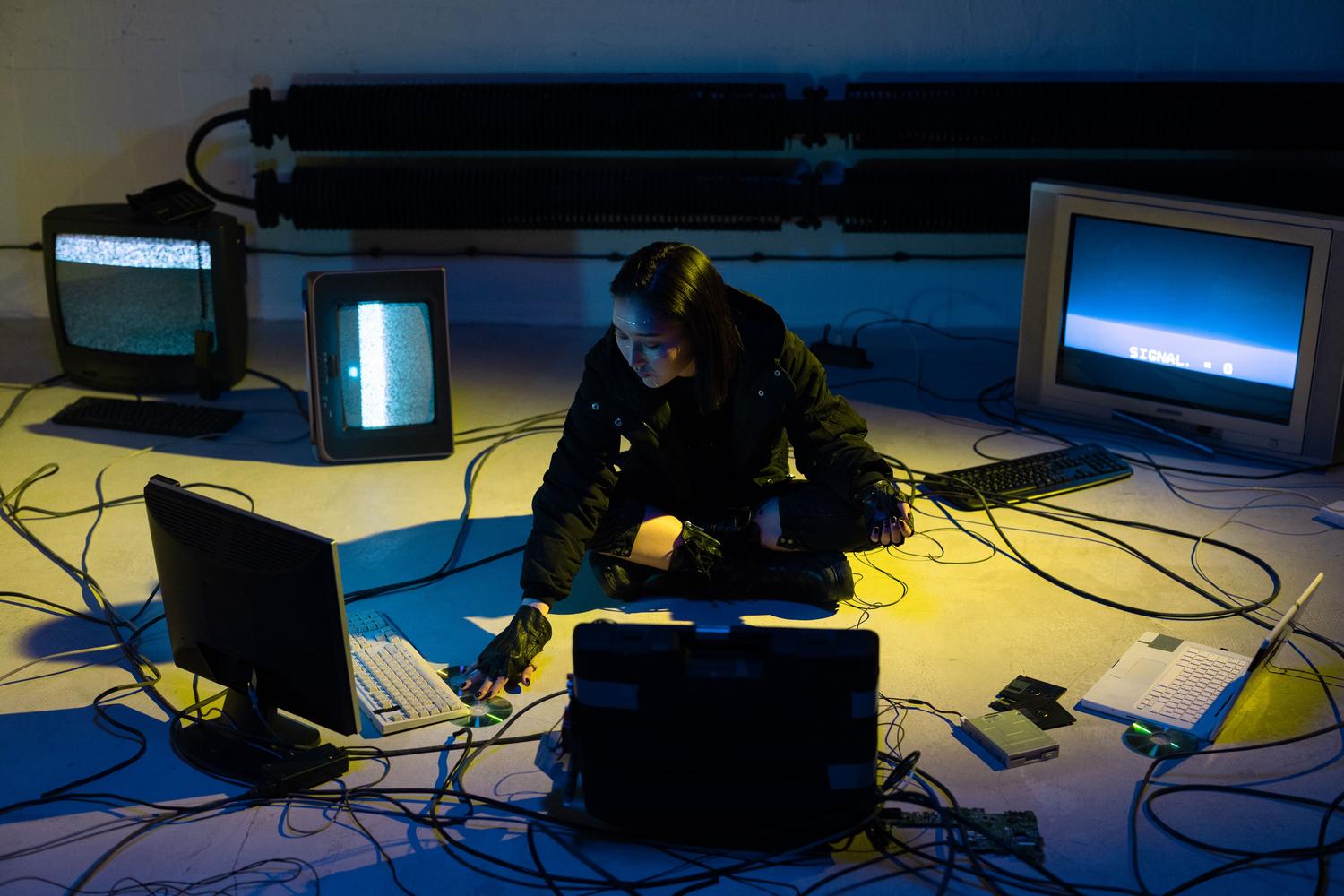 Entorno cibernético con monitores antiguos y cables, representando la posibilidad de que software malicioso corrompa archivos DLL.