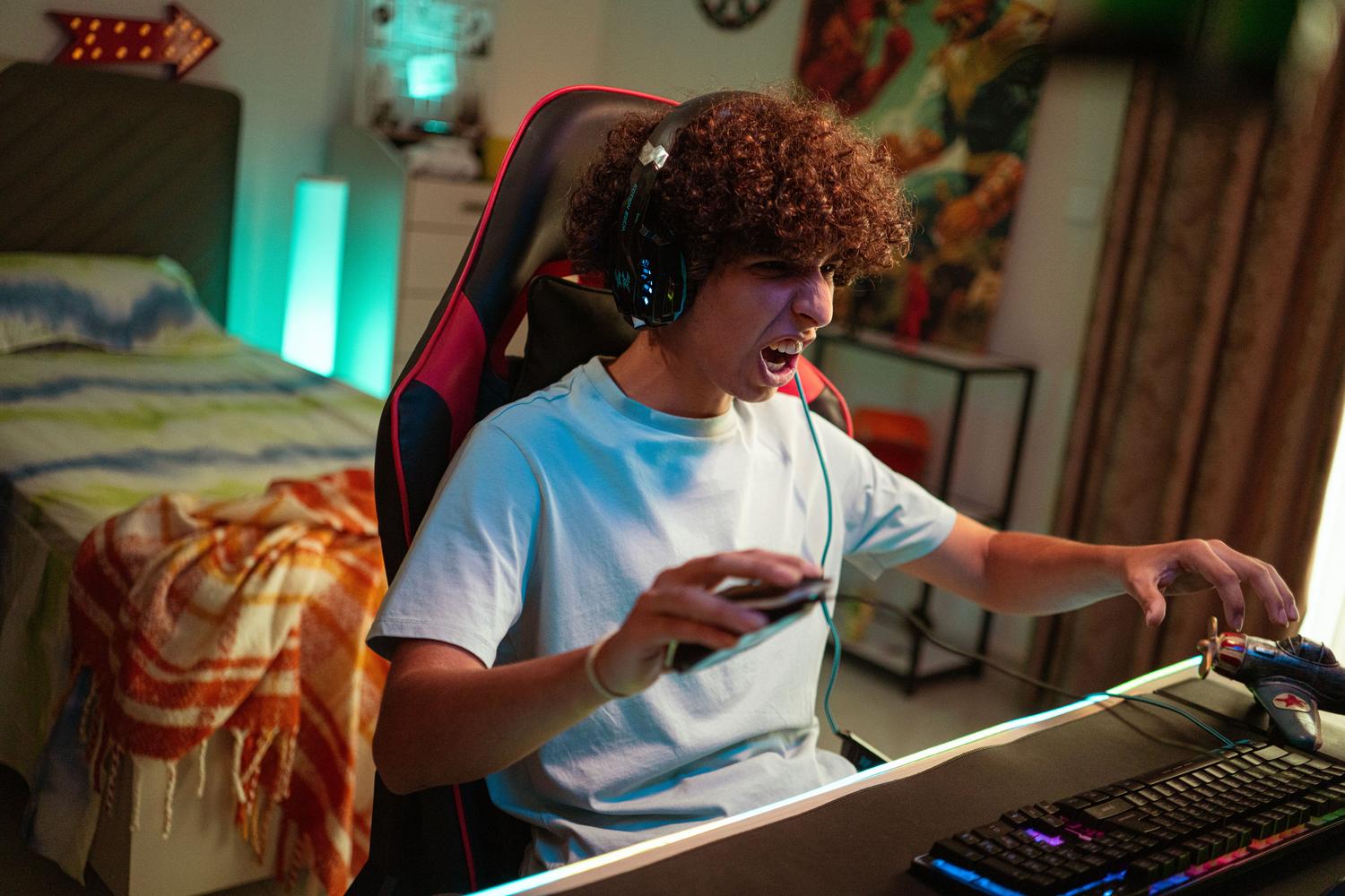 Joven gamer concentrado y emocionado jugando en su setup moderno, representando la pasión por los clásicos como PES6