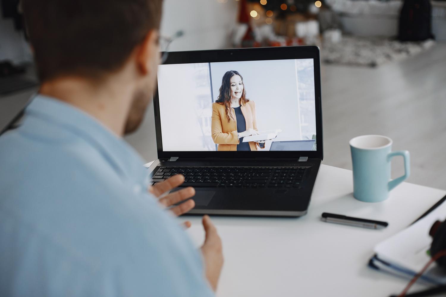 Hombre participando en una videollamada desde su casa.