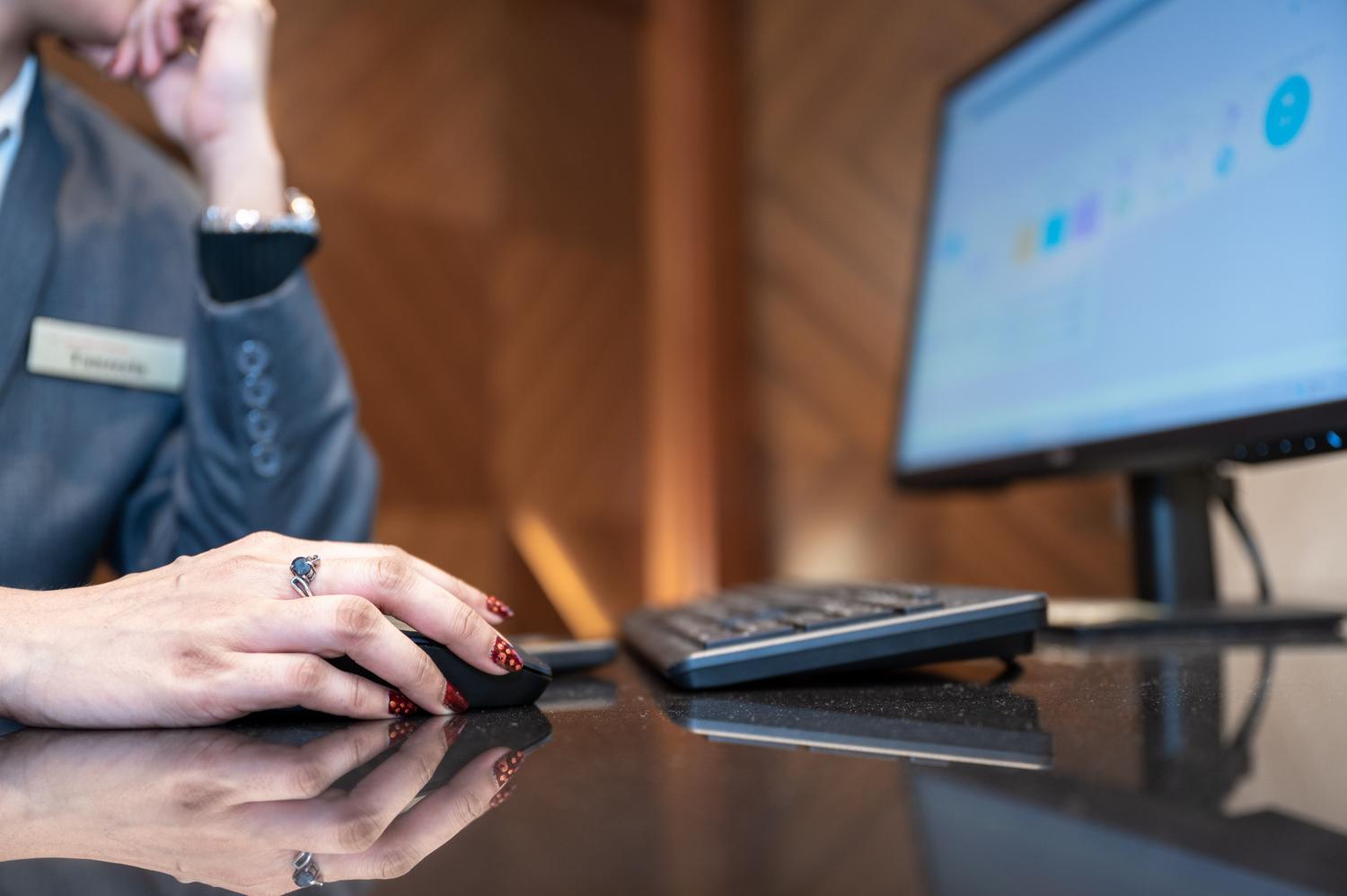 Primer plano de un profesional interactuando con un ordenador en un entorno de oficina, ilustrando la configuración de herramientas de software.