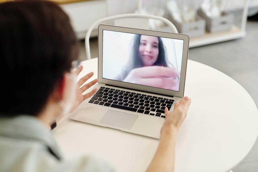 Une personne effectue un appel vidéo sur un ordinateur portable, illustrant la gestion de la caméra et du microphone.