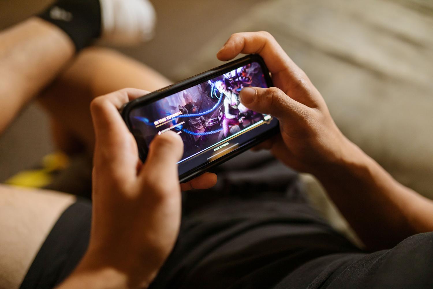 Manos jugando en la pantalla táctil de un smartphone