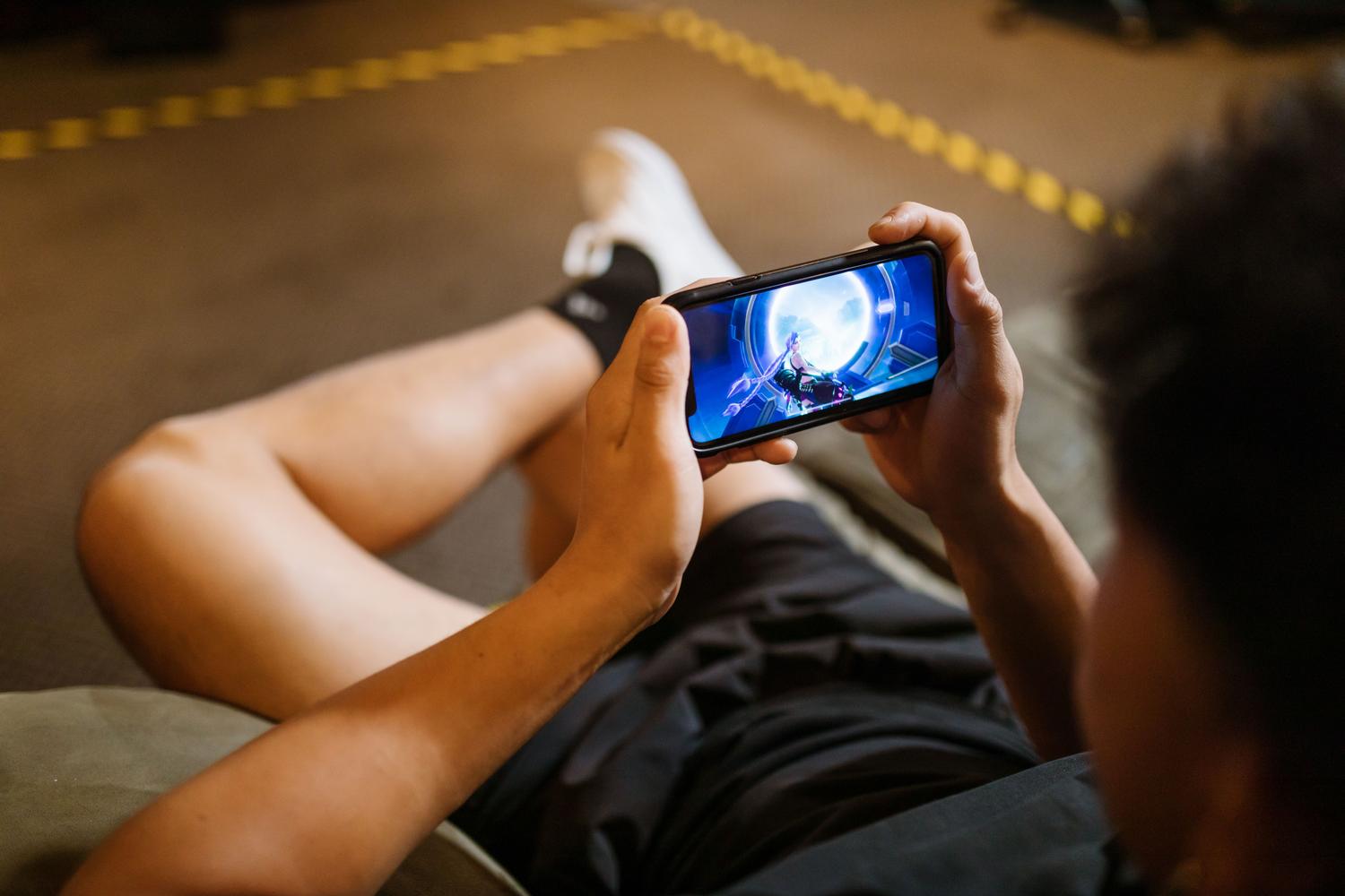Persona concentrada jugando en su teléfono móvil