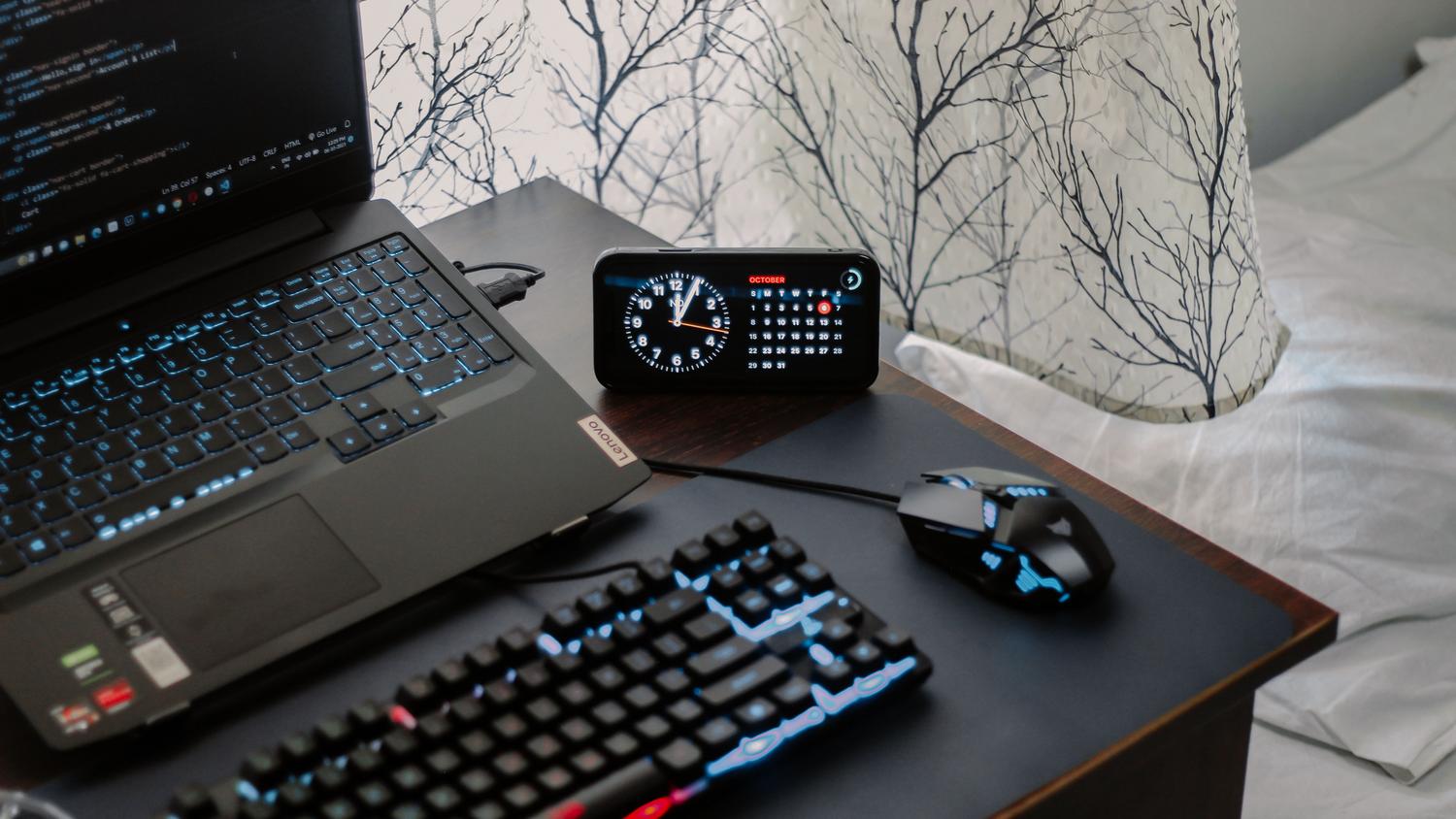 Teclado iluminado y reloj digital en un escritorio.