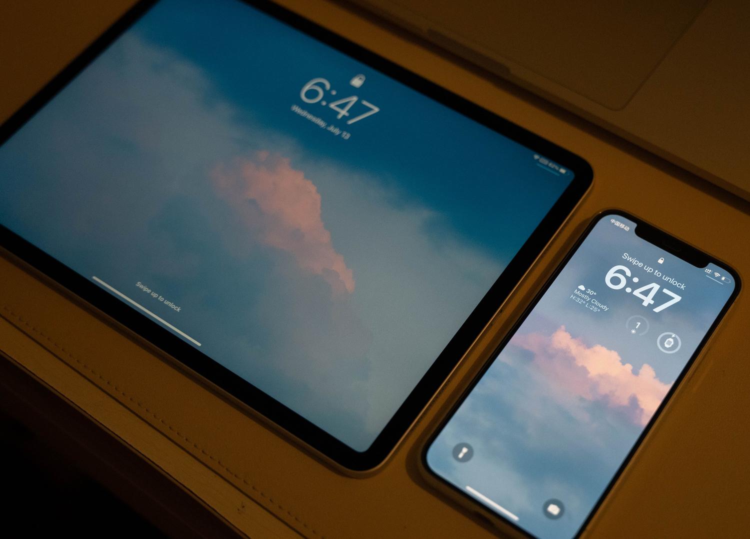 Smartphone y tablet con pantallas sincronizadas, ilustrando el concepto de sincronización de datos en la nube.