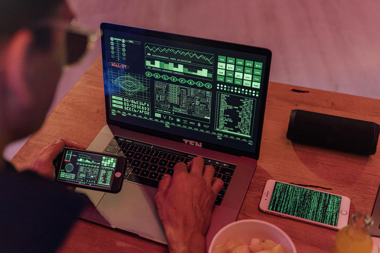Espacio de trabajo tecnológico con portátil y móviles mostrando interfaces de datos, representando la gestión e importación de archivos.