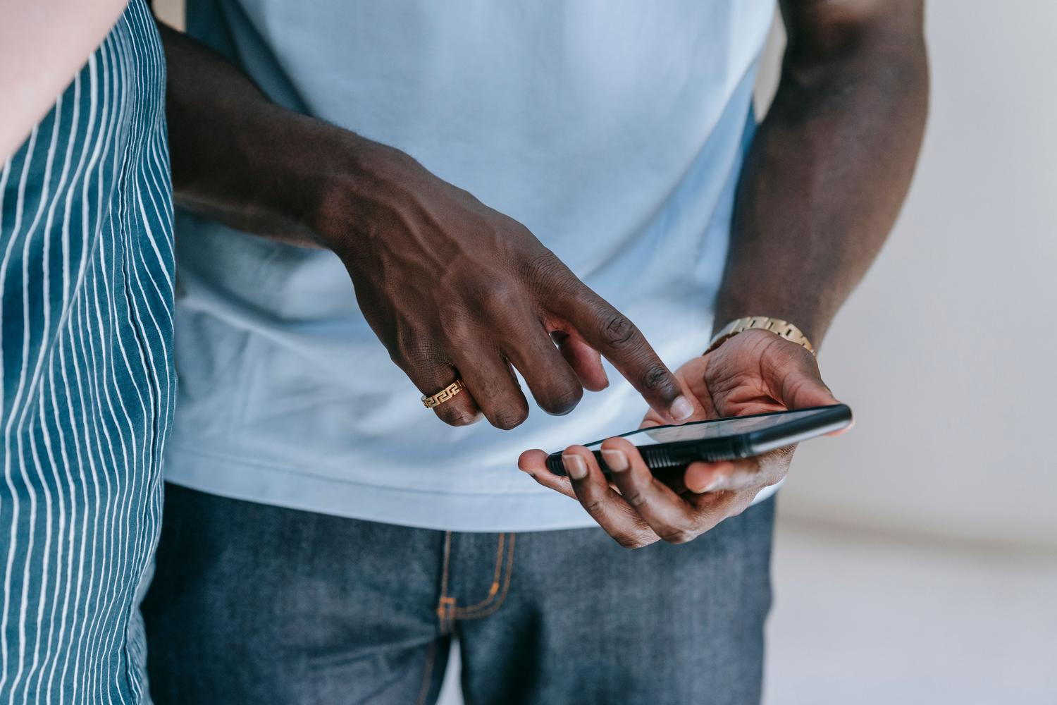Persona utilizando un smartphone en un entorno cotidiano, enfocada en la navegación del sistema.